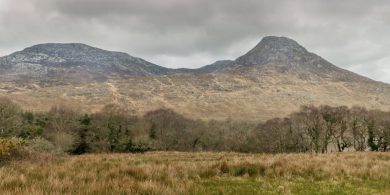 Cead páirceála i sliabhraon Gaeltachta tarraingthe siar mar gheall ar mhadraí