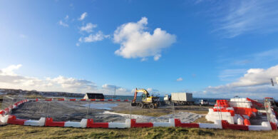 Innealra tugtha i dtír in Inis Oírr agus lucht tógála ag réiteach le tosú ag obair ar ché nua