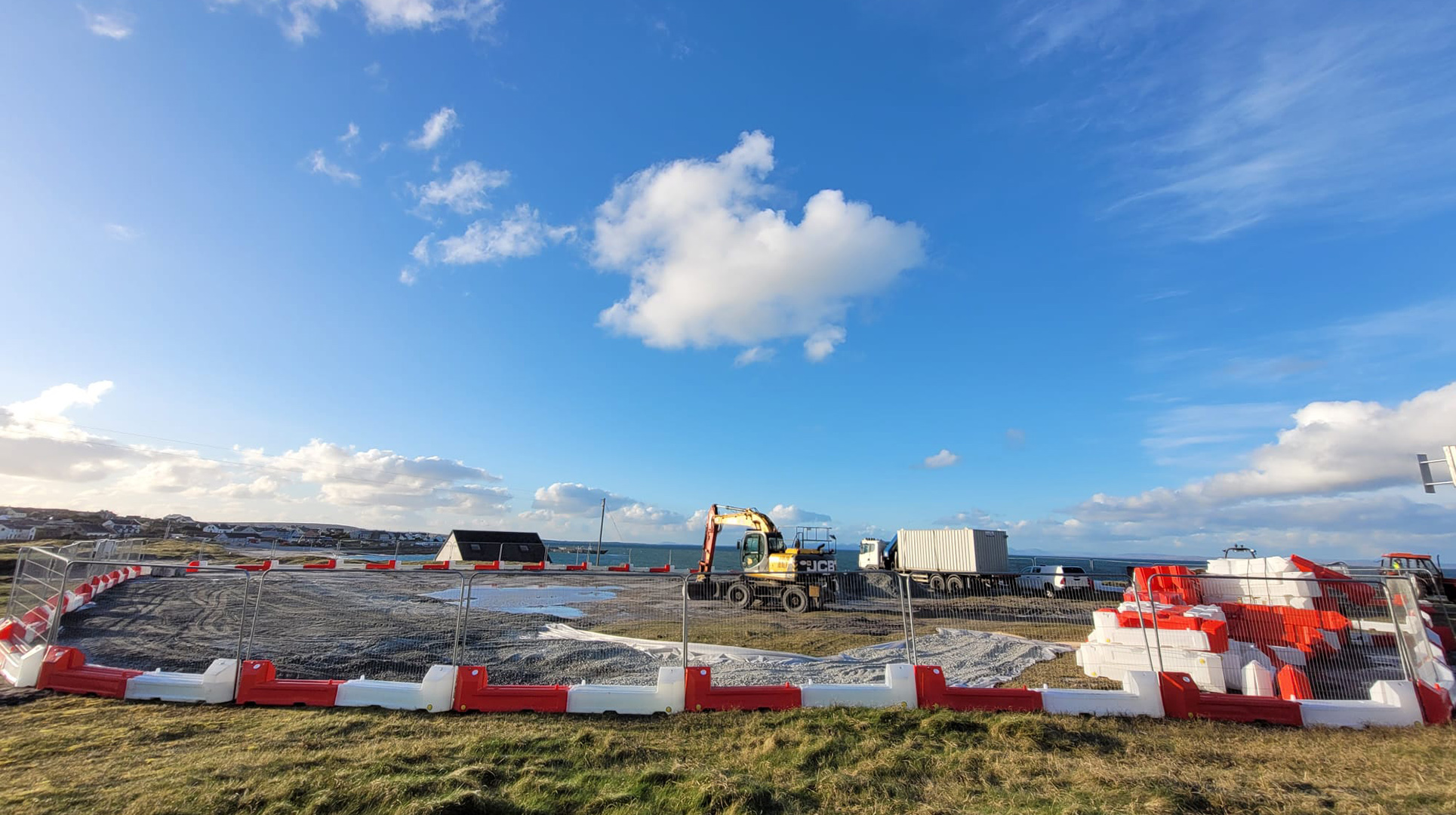 Innealra tugtha i dtír in Inis Oírr agus lucht tógála ag réiteach le tosú ag obair ar ché nua
