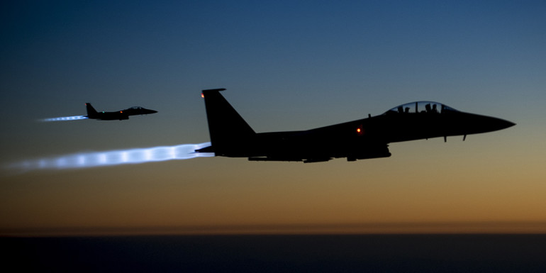 A pair of U.S. Air Force F-15E Strike Eagles fly over northern Iraq early in the morning of Sept. 23, 2014, after conducting airstrikes in Syria. These aircraft were part of a large coalition strike package that was the first to strike ISIL targets in Syria. (U.S. Air Force photo by Senior Airman Matthew Bruch/Released)