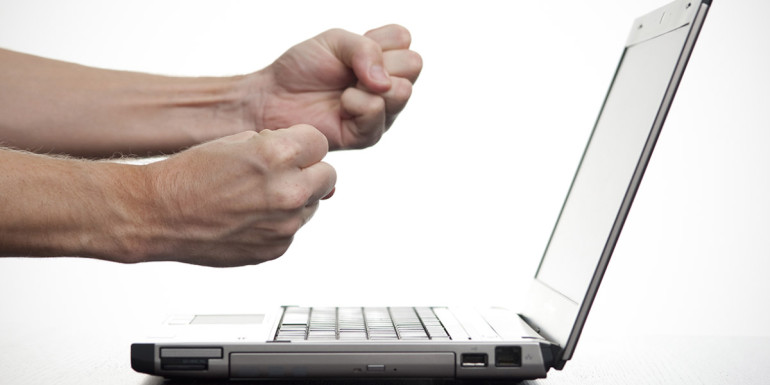 an annoyed user making fists at a computer screen