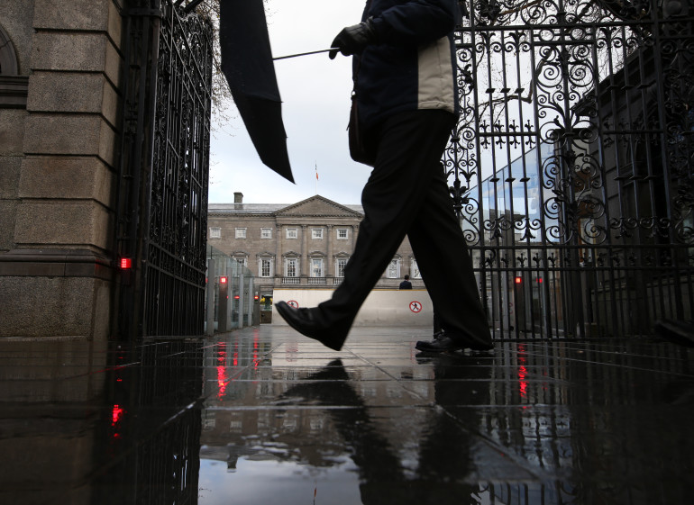 27/04/2016. Dublin Weather Scenes. Pictured a women walks past Leinster House as its reflected in a puddle after a recent hail/rain shower in Dublin this afternoon. Photo: Sam Boal/Rollingnews.ie